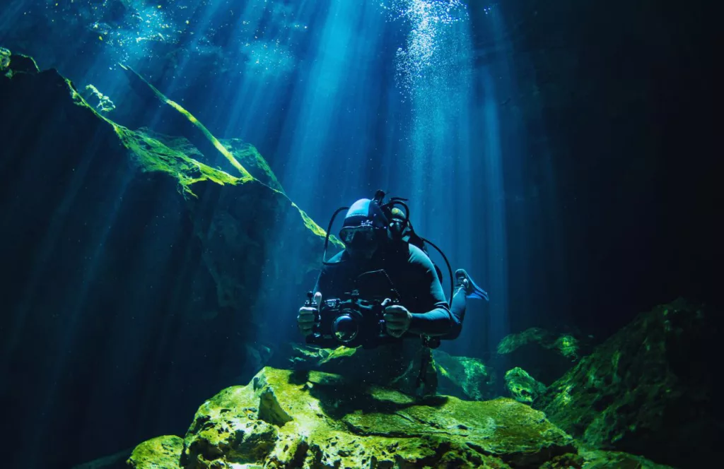 Scuba Diver with Underwater Camera. Keep reading to learn about shark watching in Florida and how to avoid attacks