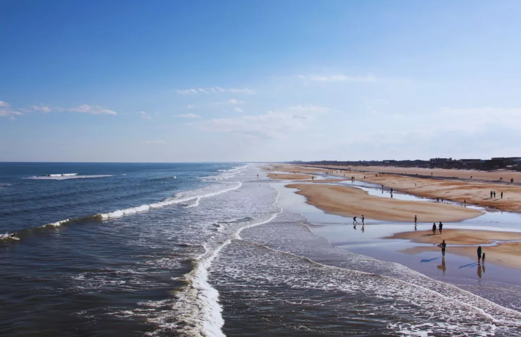 St. Augustine Beach with families playing on the sand. Keep reading to learn about the best Florida beaches for a girl's trip!