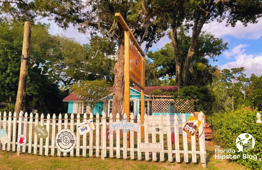 Brewery Taproom with a white vintage looking picket fence and signs posted all along of breweries. One of the best things to do in Jacksonville, Florida. Keep reading to find out all you need to know about Jacksonville breweries. 