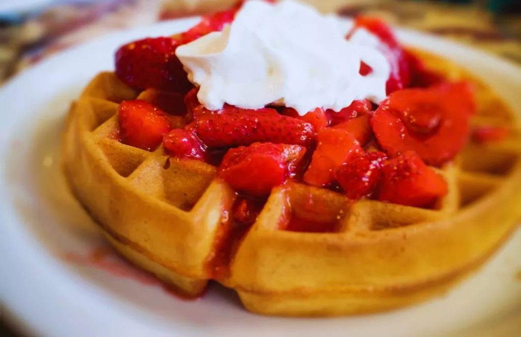 EJ's Bayfront Cafe Waffles with strawberries topped with whipped cream. Keep reading to discover where to eat in Naples.