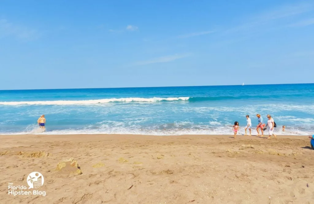 Jupiter, Florida Rocky Beach Shore with family walking. Keep reading learn about what to pack for Florida and how to create the best Florida Packing List 