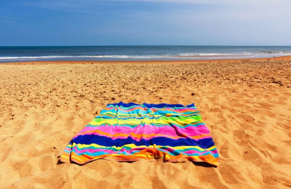 Colorful beach towel on sand in St. Pete Beach, Florida. Keep reading to learn about the best Florida beaches for a girl's trip!