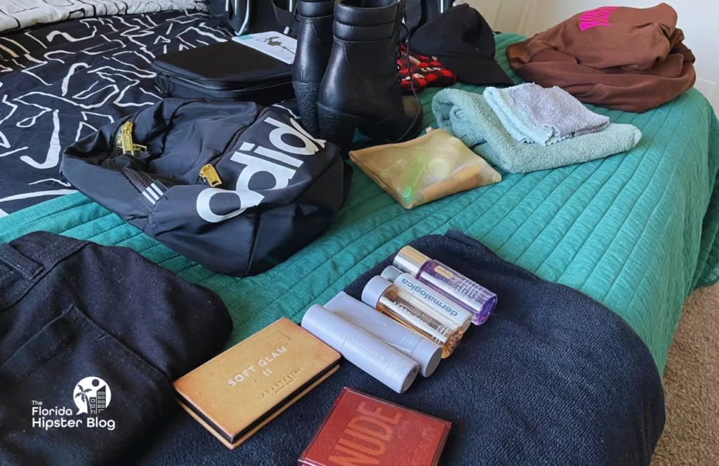 Keep reading learn about what to pack for Florida and how to create the best Florida Packing List my clothes laid out on the bed with backpack. Keep reading to get the best snacks to take to Disney World.