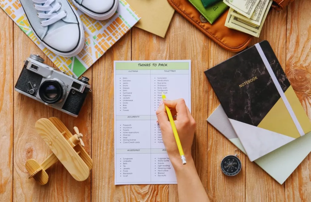 Florida Packing List on table next to journal camera shoes and money. Keep reading to get the Essentials You MUST HAVE for Your Convention Packing List and What to Bring to a Convention.