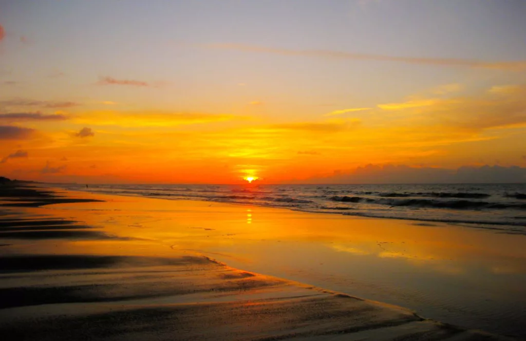 Topsail Hill Preserve State Park at sunset with bright vibrant oranges. Keep reading to find out more about the public beaches in Destin.  