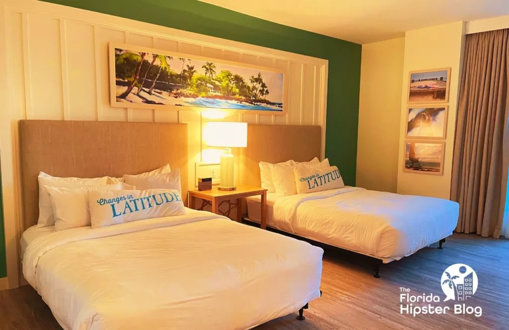 Margaritaville Resort Jacksonville suite with two beds with fresh linens decorated with beach art on the walls. Keep reading to find out more about Margaritaville Beach Hotel Jacksonville.