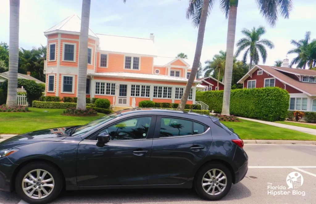 Naples, Florida light orange doll style house in the neighbor with black car. One of the best Florida beaches in May.