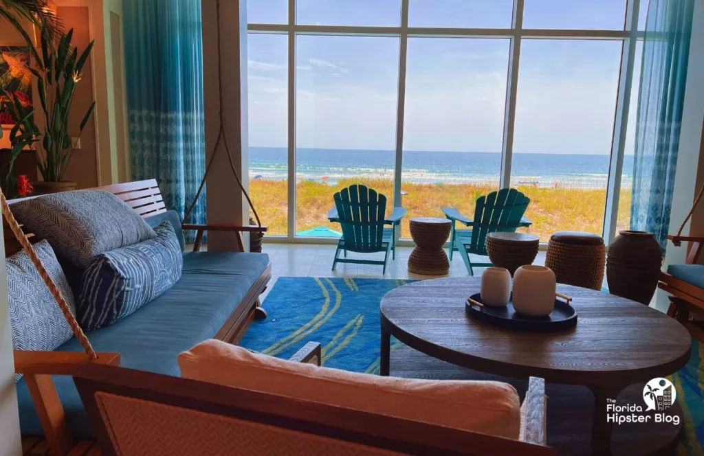 Margaritaville Beach Hotel Lobby with grand windows with a view of the water and adirondack chairs and beach decor. Keep reading to get the best beaches in florida for bachelorette party.