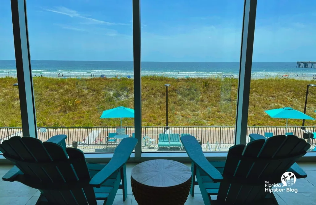 Margaritaville Beach Hotel lobby with beach bungalow chairs looking out the ocean view. Keep reading to find out all about Margaritaville Hotel Jacksonville Beach.