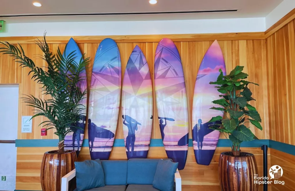 Margaritaville Beach Hotel lobby and Landshark Lookout area with a couch and surfboard art along the wall. Keep reading to learn more about Margaritaville Hotel Jacksonville Beach.