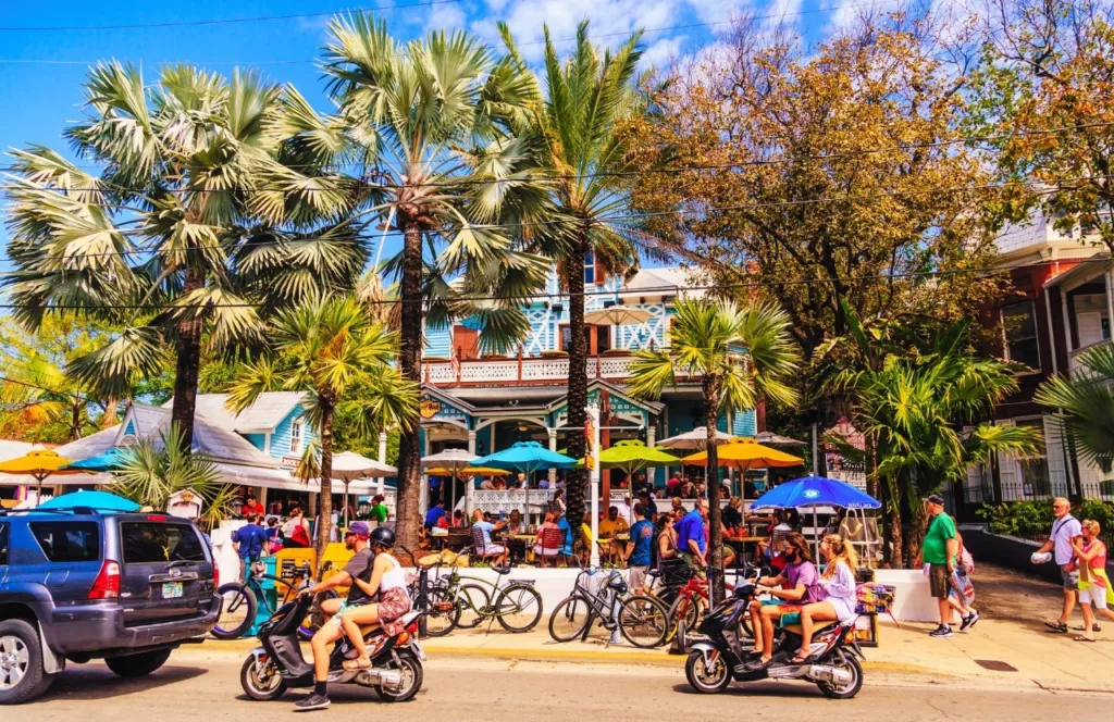 Scooters passing by the bar in Key West, Florida. Keep reading to get the best beaches in florida for bachelorette party.