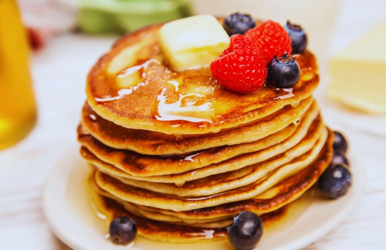 Skillet's Restaurant Pancakes topped with butter syrup raspberries and blueberries. One of the best places to get brunch in Naples, Florida