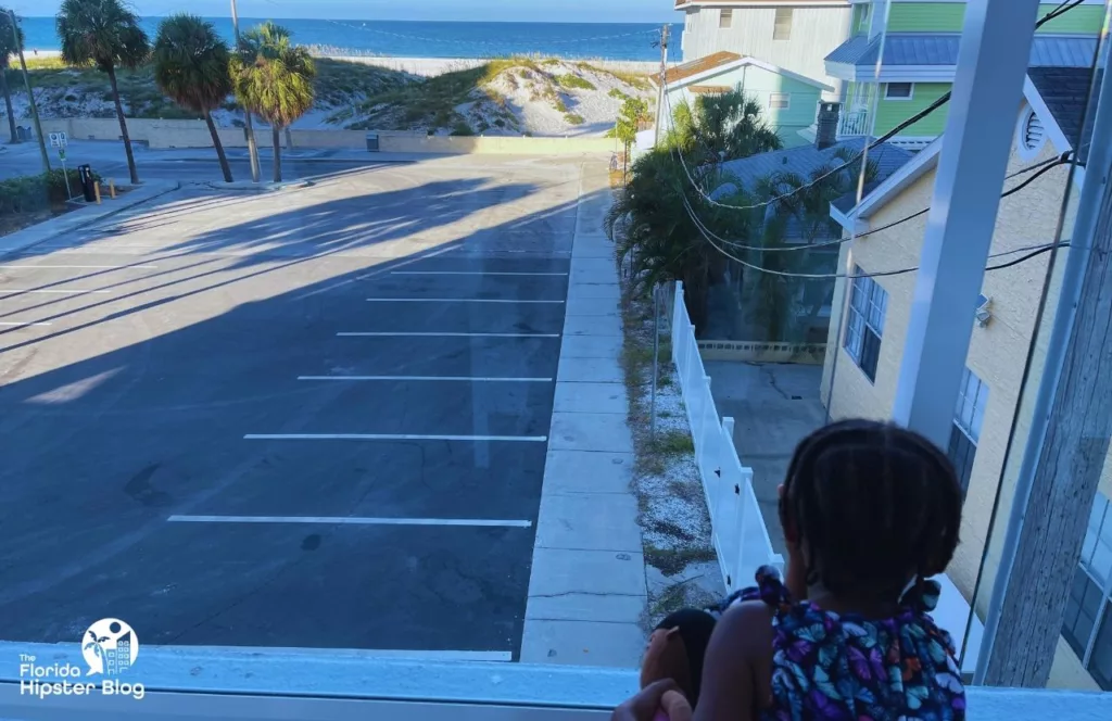The Avalon Hotel in Clearwater little black girl looking out the window at the Gulf of Mexico beach. Keep reading to uncover more about the Avalon Club Hotel Clearwater Beach.