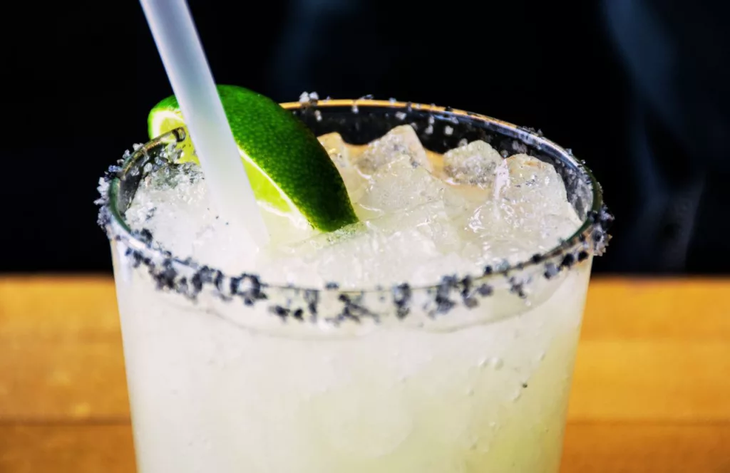 Margarita with with a lime on the table. Keep reading to discover the best outdoor dining in Gainesville.