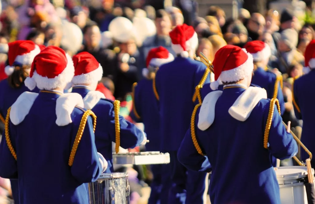 City of Gainesville Holiday Parade with marching band members in Santa Claus hats. Keep reading to find out more events in Gainesville for Christmas. 