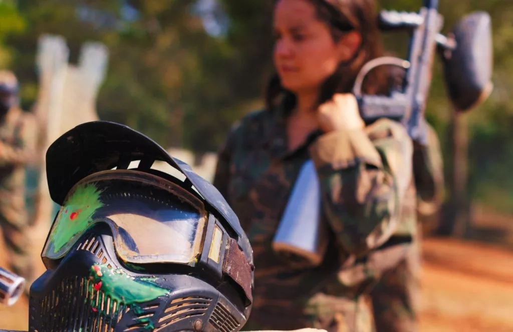 Brave Lady next to Paintball mask. Keep reading to get the Best Paintball Fields in Orlando, Florida.