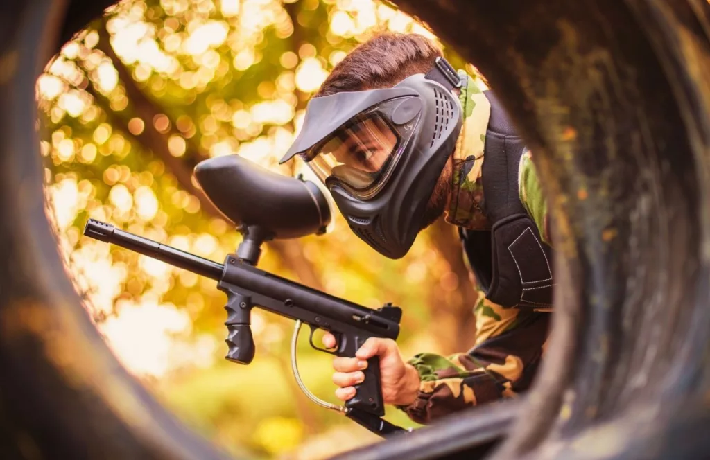 Guy creeping through the woods playing game. Travel Guide to the Best Paintball Fields in Orlando, Florida. Keep reading to learn more about the best paintball fields in Orlando, Florida.