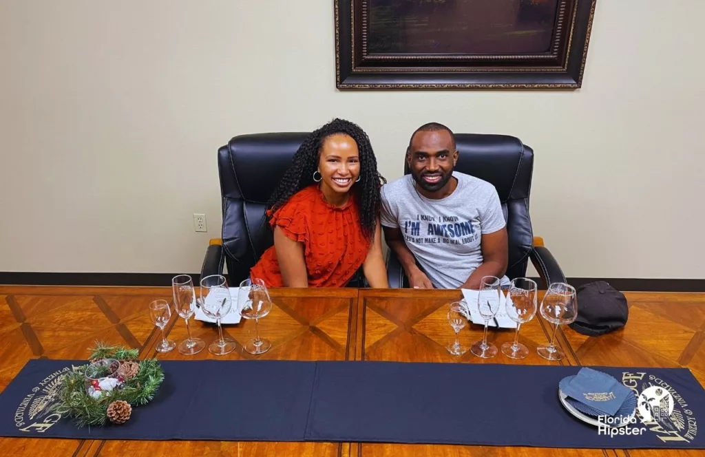 NikkyJ and partner sitting at the table for the Private VIP Tour Wine Tasting at Lakeridge Winery in Clermont, Florida. Keep reading to learn more about Florida’s largest winery. 