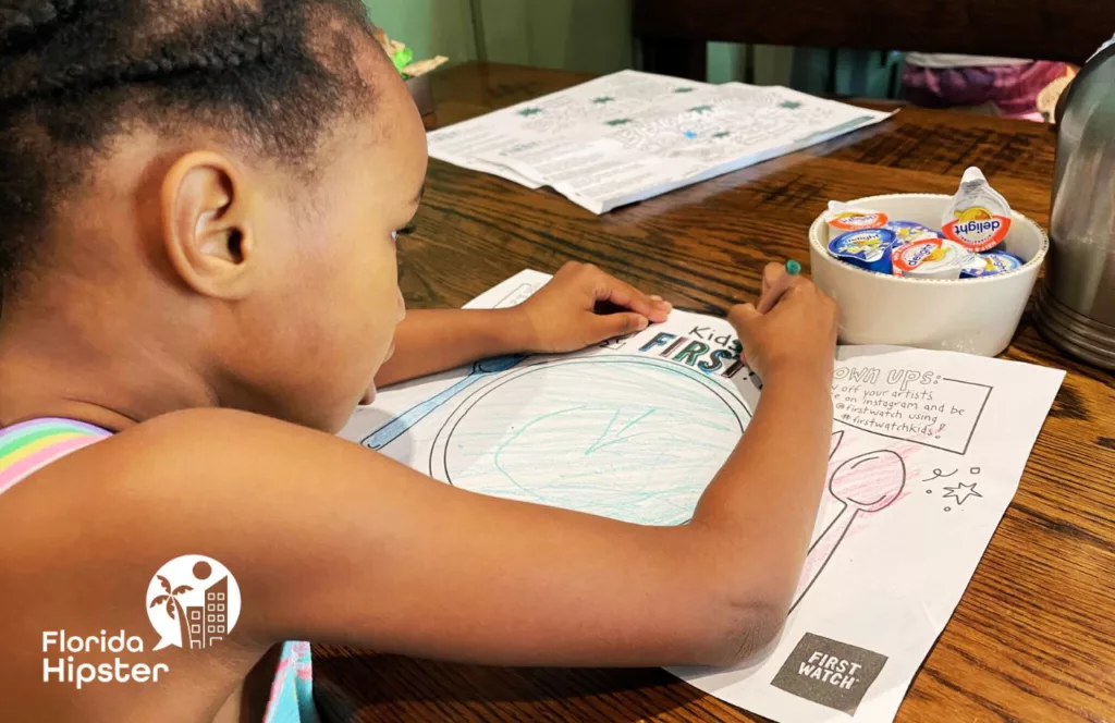 Little girl coloring at First Watch Breakfast and Brunch Restaurant. Keep reading for the best breakfast restaurants in Orlando, Florida.