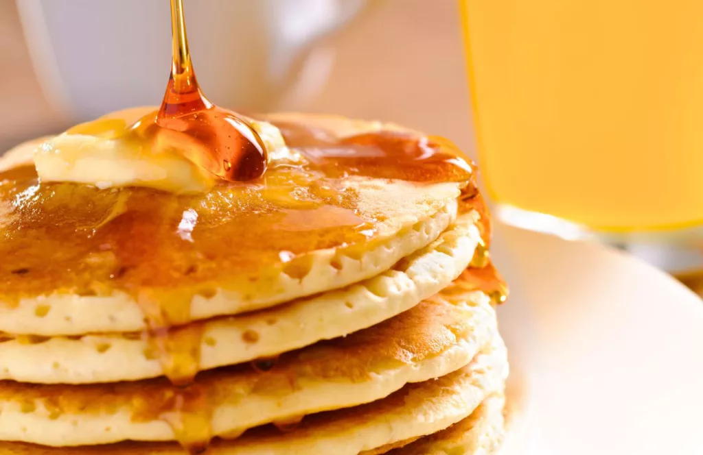 The Pancakery of PCB with a big fluffy plate of pancakes covered in syrup. One of the best places to get breakfast in Panama City Beach, Florida with delicious pancakes. Keep reading to find out all about breakfast in Panama City Beach.