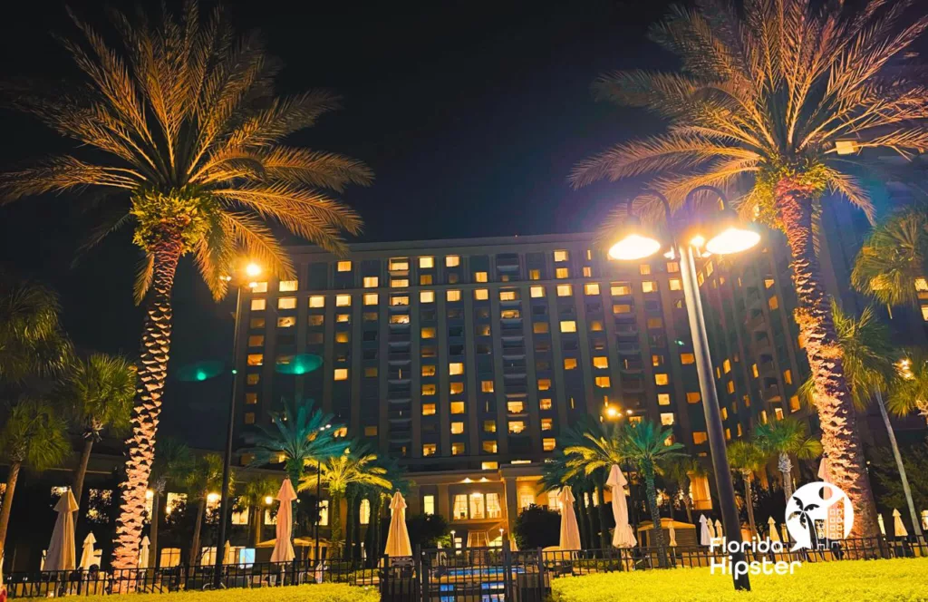 Exterior view of  Waldorf Astoria Resort lit up with giant palms in front. Keep reading to get more date ideas in Orlando.