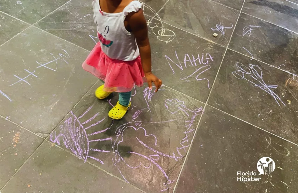 Crayola Experience little girl playing with chalk. Keep reading to discover more ideas for Orlando with toddlers.  